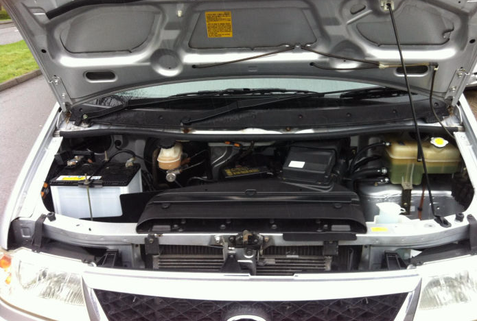 The engine bay of a Mazda Bongo during a specialist service.